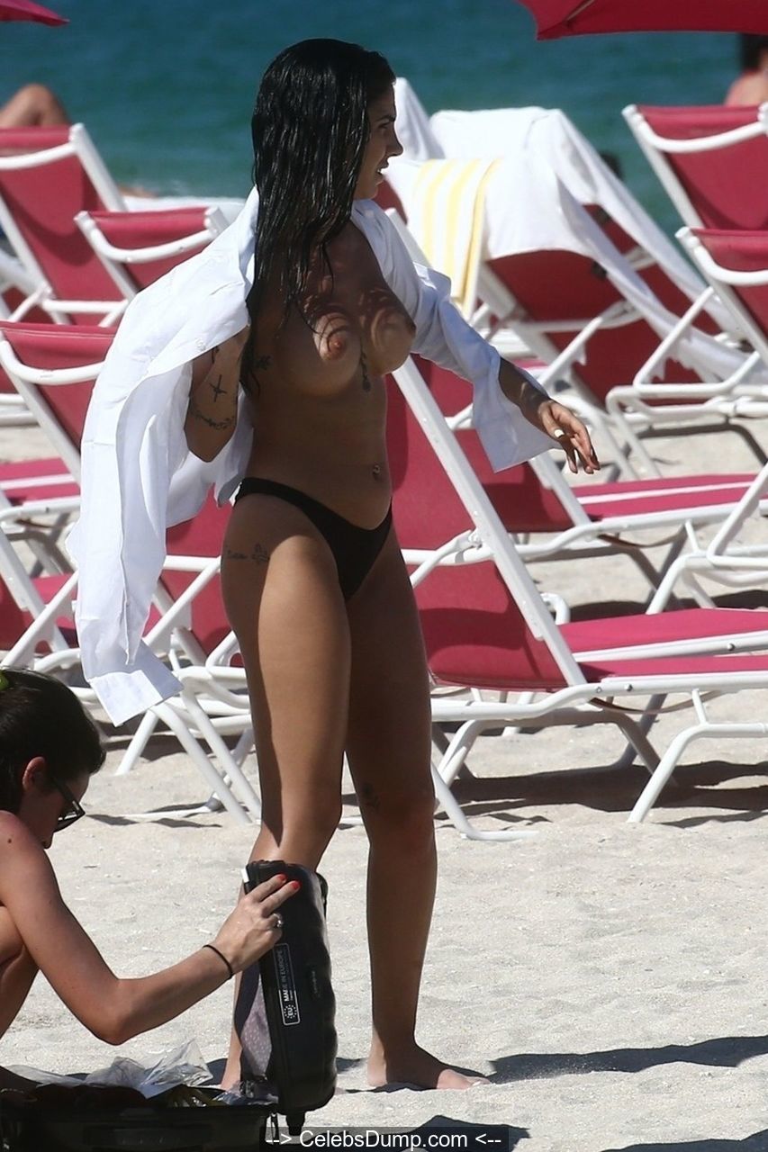 Giulia De Lellis poses tpless on a beach during a photoshoot in Miami Beach...