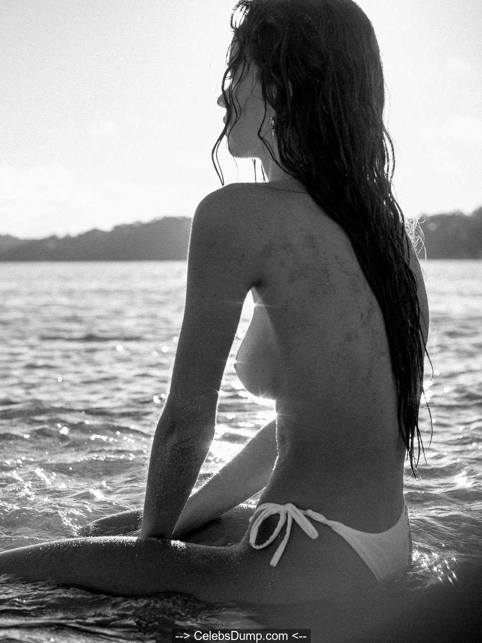 Isabelle Mathers topless on a beach by Tim Swallow.