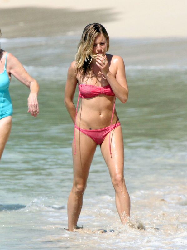 Sienna Miller in pink bikini on a beach in Barbados - April 01, 2010.